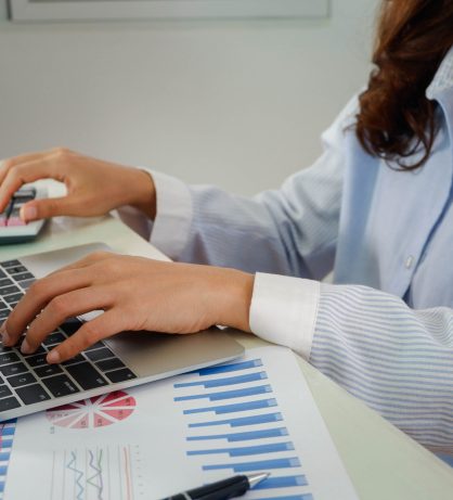 Asian women are working on laptops. Female hands typing on the n Asian women are working on laptops. Female hands typing on the notebook keyboard. Working at home concept.